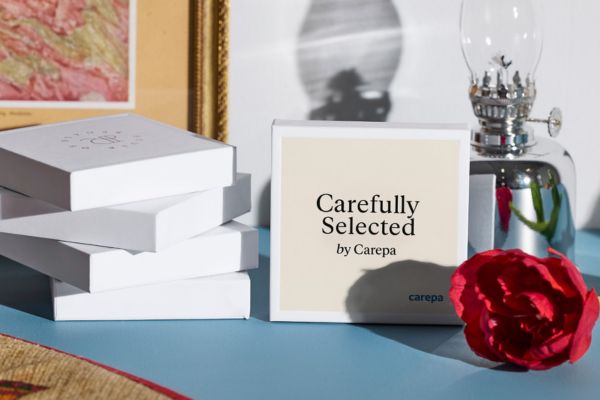 Gåvokort "Carefully Selected by carepa" i ask som står på´ett bord.