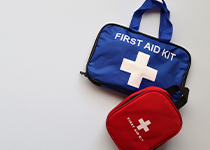 En blå första hjälpen-väska och en röd förstahjälpen-väska som ligger snett över den andra. 