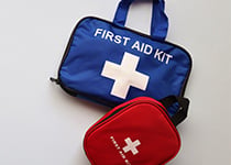 En blå första hjälpen-väska och en röd förstahjälpen-väska som ligger snett över den andra