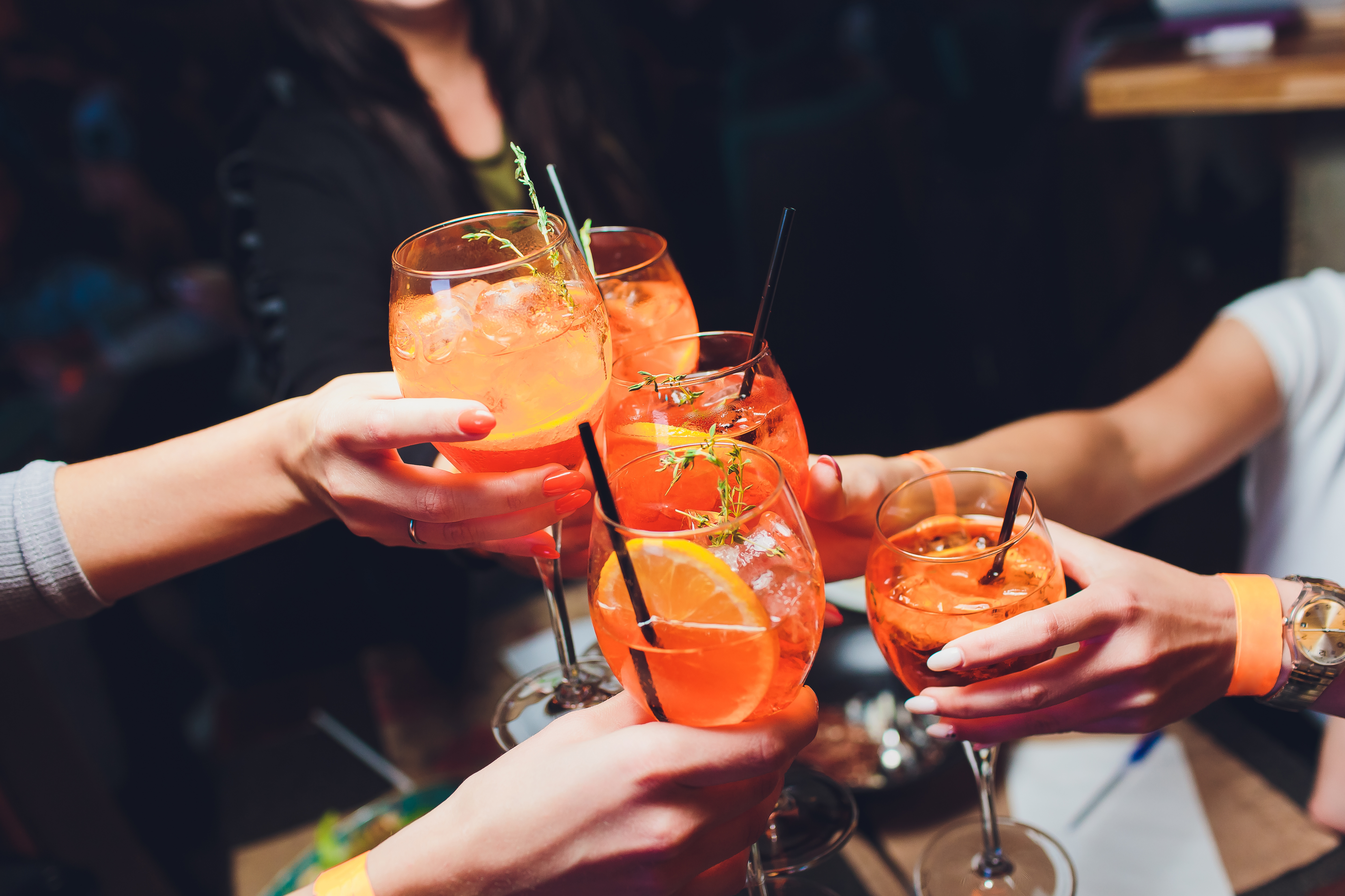 Aperol spritz i glas som skålar med varandra i luften